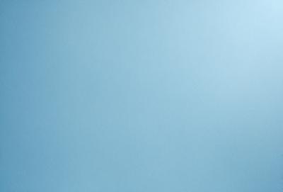 The primary subject of the image is a clear blue sky. The setting is a vast, open space with no visible landmarks or objects. The visual style is a natural, untouched landscape. The colors and mood are serene and peaceful, with the blue sky creating a calm and tranquil atmosphere.