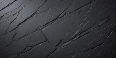 The primary subject of the image is a close-up of a black stone wall. The setting is a dark room, and the visual style is a black and white photo. The dominant colors are black and white, creating a moody atmosphere.