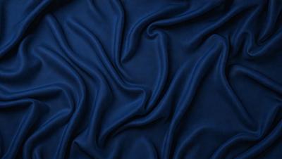 The primary subject of the image is a blue fabric, which appears to be a piece of cloth or a curtain. The setting is a dark background, which contrasts with the blue fabric. The visual style is a close-up of the blue fabric, showcasing its texture and details. The colors and mood of the image are predominantly blue, creating a calm and serene atmosphere.