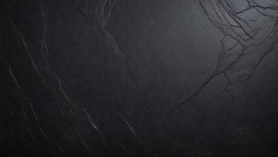 The primary subject of the image is a black marble countertop. The setting is a dark room, and the visual style is a close-up of the marble countertop. The countertop appears to be a dark grey color, giving it a sophisticated and elegant appearance.