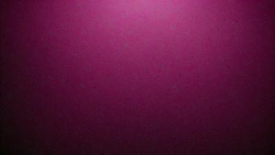 The primary subject of the image is a large, pink wall. The setting is a dark room, and the visual style appears to be a photo. The dominant colors are pink and purple, creating a warm and inviting atmosphere.