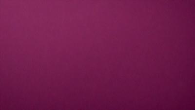 The primary subject of the image is a large, purple wall. The setting is a room with a pink background. The visual style is a close-up of the wall, which gives a sense of depth and texture. The dominant colors are purple and pink, creating a warm and inviting atmosphere.