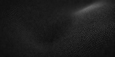 The primary subject of the image is a close-up of a black surface with a pattern of small holes. The setting appears to be a dark room, and the visual style is a black and white photo. The dominant colors are black and white, and the overall atmosphere is somewhat mysterious and intriguing.