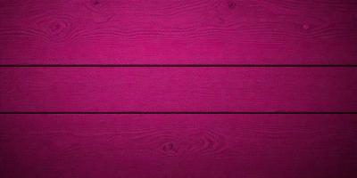 The primary subject of the image is a wooden surface, possibly a wall or a table, with a pink color. The setting appears to be indoors, and the visual style is a close-up of the wooden surface. The dominant colors in the image are pink and brown, creating a warm and inviting atmosphere.