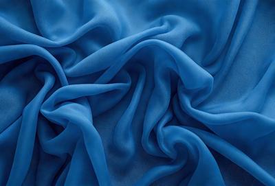 The primary subject of the image is a blue fabric, which appears to be a piece of cloth or a curtain. The setting is a room with a blue background, which complements the blue fabric. The visual style is a close-up of the blue fabric, showcasing its texture and details. The colors and mood of the image are predominantly blue, creating a calm and serene atmosphere.