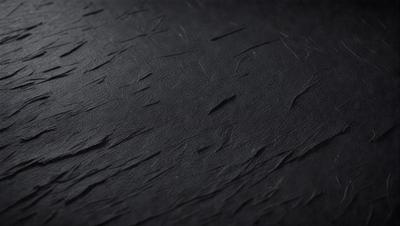 The primary subject of the image is a close-up of a black leather surface. The setting is a dark room, and the visual style appears to be a photo. The dominant colors are black and white, creating a moody atmosphere.