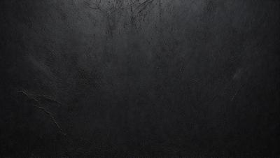 The primary subject of the image is a black leather surface. The setting is a dark room, and the visual style is a close-up of the leather surface. The colors and mood of the image are predominantly dark and moody, with the black leather being the main focus.