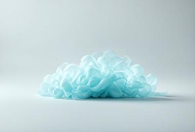 The primary subject of the image is a large, blue, cloud-like object. It is placed on a white surface, which serves as the background. The visual style of the image is a combination of photo and digital art, creating a unique and artistic representation of the cloud. The dominant colors in the image are blue and white, giving it a calm and serene atmosphere.