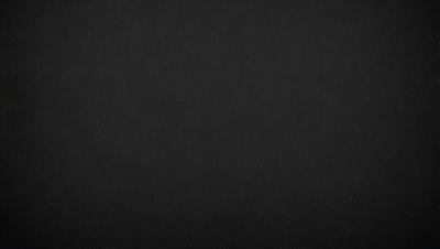 The primary subject of the image is a black background. The setting is a dark, empty space with no visible objects or elements. The visual style is a black and white photo, which gives the image a classic and timeless appearance. The colors and mood are predominantly dark and moody, creating a sense of mystery and depth.