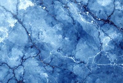 The primary subject of the image is a blue marble wall with a pattern of white and blue veins. The setting is a room with a blue marble floor. The visual style is a close-up of the marble wall, showcasing the intricate vein patterns. The colors and mood of the image are predominantly blue, creating a serene and calming atmosphere.