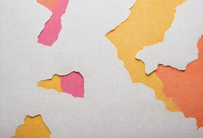 The primary subject of the image is a piece of paper with a yellow background. The paper has a pattern of pink and orange shapes cut out of it, creating a visually interesting and artistic display. The setting appears to be a table or a workspace, where the paper is placed. The visual style of the image is a combination of digital art and illustration, as the paper has been cut and arranged in a creative manner. The colors and mood of the image are vibrant and lively, with the pink and orange shapes adding a sense of warmth and energy to the scene.