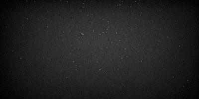 The primary subject of the image is a black background with a pattern of white stars. The setting is a dark, starry night, and the visual style is a black and white photo. The dominant colors are black and white, and the overall atmosphere is serene and peaceful.
