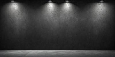 The primary subject of the image is a large, gray wall with a light shining on it. The setting is a room with a concrete floor. The visual style is a black and white photo, giving the image a classic and timeless appearance. The dominant colors are gray and black, creating a moody and dramatic atmosphere.