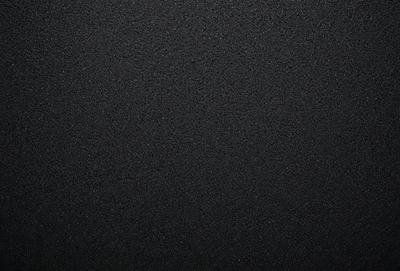 The primary subject of the image is a black background. The setting is a dark, empty space with no visible objects or elements. The visual style is a black and white photo, which gives the image a classic and timeless appearance. The colors and mood are predominantly dark and moody, creating a sense of mystery and depth.