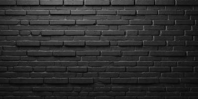 The primary subject of the image is a black brick wall. The setting is a brick wall, and the visual style is a photo. The dominant colors are black and the overall atmosphere is dark and moody.