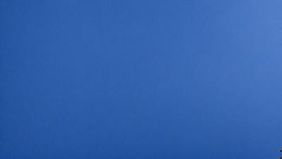 The primary subject of the image is a large, open blue sky. The setting is a vast, empty space with no visible landmarks or objects. The visual style is a natural, untouched landscape. The colors and mood are predominantly blue, creating a serene and peaceful atmosphere.