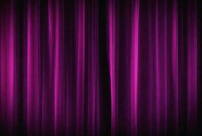 The primary subject of the image is a purple curtain. The setting is a stage or a theater, as the curtain is drawn back to reveal the stage. The visual style is a photo, capturing the purple curtain and the stage behind it. The colors and mood of the image are predominantly purple, creating a dramatic and theatrical atmosphere.