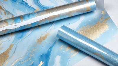The primary subject of the image is a roll of blue and gold metallic paper. The paper is sitting on a table, and it appears to be a decorative material. The setting is a table with a blue and gold metallic paper roll, and the visual style is a close-up of the paper roll. The colors and mood of the image are predominantly blue and gold, creating a visually appealing and elegant atmosphere.
