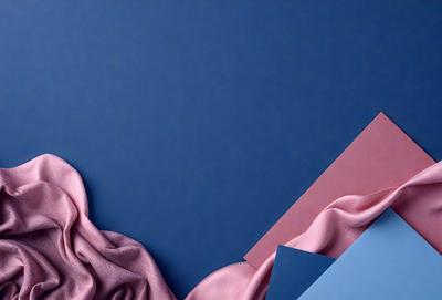 The primary subject of the image is a pink and blue fabric, which is the main focus of the scene. The setting is a blue wall, providing a contrasting background for the fabric. The visual style of the image is a combination of photo and digital art, creating a unique and eye-catching presentation. The dominant colors in the image are pink and blue, giving the scene a vibrant and lively atmosphere.
