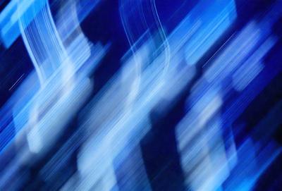 The primary subject of the image is a blue background with a blurry, out-of-focus cityscape. The setting is a nighttime cityscape, with the buildings and lights creating a sense of depth and atmosphere. The visual style is a blend of photo and digital art, with the cityscape appearing as a blurry, out-of-focus image. The colors and mood are predominantly blue, creating a calm and serene atmosphere.
