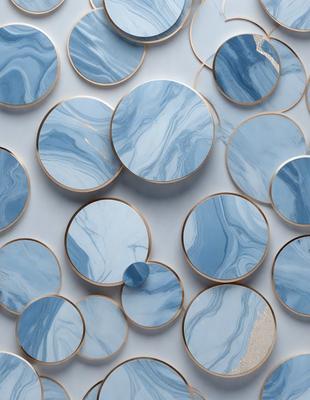 The primary subject of the image is a collection of round, blue marble tiles. These tiles are arranged in a visually appealing pattern, creating a striking and cohesive design. The setting is a white wall, which serves as a clean and neutral backdrop for the tiles. The visual style of the image is a close-up of the tiles, showcasing their intricate details and textures. The dominant colors in the image are blue and white, giving the scene a calm and sophisticated atmosphere