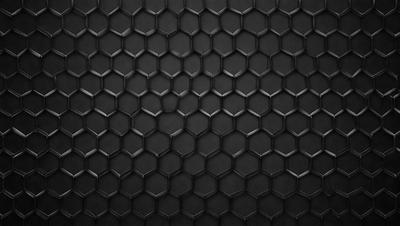 The primary subject of the image is a black and white patterned surface, which appears to be a black background with a geometric pattern. The setting is a dark room, and the visual style is a close-up of the pattern. The colors and mood of the image are predominantly dark and moody, with the black and white pattern creating a sense of depth and contrast.