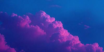 The primary subject of the image is a large, pink cloud in the sky. The cloud is the main focus of the image, and it appears to be a natural formation rather than a digital or artificial creation. The setting is a cloudy sky, which provides a backdrop for the cloud. The visual style of the image is a close-up of the cloud, allowing the viewer to appreciate its details and texture. The colors and mood of the image are predominantly pink, which gives the scene a warm and serene