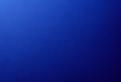 The primary subject of the image is a large, dark blue sky. The setting is a vast, open space with no visible landmarks or objects. The visual style is a natural, untouched environment. The colors and mood are predominantly dark and moody, with the blue sky serving as the main focal point.