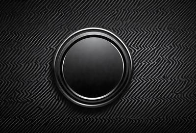 The primary subject of the image is a black button with a circular shape. The button is located on a black background, which creates a contrasting visual effect. The overall atmosphere of the image is dark and moody, with the black button being the focal point.