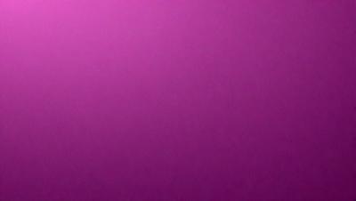 The primary subject of the image is a large, purple wall. The setting is a room with a pink background. The visual style is a close-up of the wall, which gives a sense of depth and texture. The dominant colors are purple and pink, creating a warm and inviting atmosphere.
