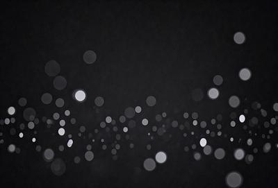 The primary subject of the image is a black background with a pattern of white lights. The setting is a dark room, and the visual style is a close-up of the white lights. The colors and mood of the image are predominantly dark and moody, with the white lights providing a contrasting and illuminating effect.