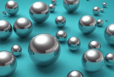 The primary subject of the image is a collection of silver balls, which are the main objects in the scene. The setting is a blue background, which creates a contrasting and visually appealing environment. The visual style of the image is a combination of photo and digital art, as it appears to be a close-up of the balls, yet the overall atmosphere is bright and lively.