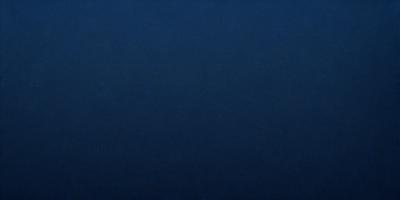 The primary subject of the image is a large, dark blue surface. The setting is a vast, open space with no visible objects or people. The visual style is a close-up of the blue surface, which gives the image a sense of depth and focus. The colors and mood of the image are predominantly dark and moody, with the blue surface creating a sense of calmness and tranquility.