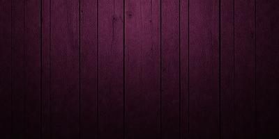 The primary subject of the image is a wooden wall with a purple color. The setting is a room with a wooden surface, and the visual style is a close-up of the wooden wall. The dominant colors are purple and brown, creating a warm and cozy atmosphere.