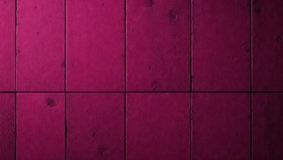 The primary subject of the image is a large, pink wall with a wooden texture. The setting is a room with a wooden floor, and the visual style is a close-up of the wall. The dominant colors are pink and brown, creating a warm and inviting atmosphere.