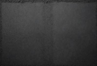 The primary subject of the image is a black and white photo of a wall. The setting is a dark room, and the visual style is a close-up of the wall. The colors and mood of the image are predominantly dark and moody, with the black and white color scheme adding to the atmosphere.