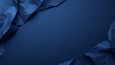 The primary subject of the image is a blue surface, which appears to be a piece of paper or a blue background. The setting is a dark room, and the visual style is a close-up of the blue surface. The colors and mood of the image are predominantly dark and moody, with the blue surface being the main focus.