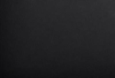 The primary subject of the image is a black background. The setting is a dark room, and the visual style is a black and white photo. The colors and mood of the image are predominantly dark and moody, with no bright colors or vibrant tones.