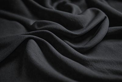 The primary subject of the image is a black fabric, which appears to be a piece of cloth or a curtain. The setting is a dark room, and the visual style is a close-up of the fabric. The colors and mood of the image are predominantly dark, with the black fabric being the main focus.