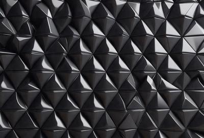 The primary subject of the image is a black and white patterned wall. The setting is a black background, and the visual style is a close-up of the pattern. The dominant colors are black and white, creating a bold and striking atmosphere.