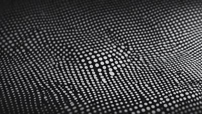 The primary subject of the image is a pattern of dots on a black background. The setting is a black surface, and the visual style appears to be a digital art or illustration. The dominant colors are black and white, creating a simple and clean appearance. The overall atmosphere of the image is minimalistic and modern.