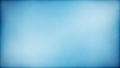 The primary subject of the image is a large, empty blue sky. The setting is a vast, open space with no clouds or other objects visible. The visual style is a realistic representation of the sky, with no indication of digital art or illustration. The colors and mood of the image are predominantly blue, creating a calm and serene atmosphere.