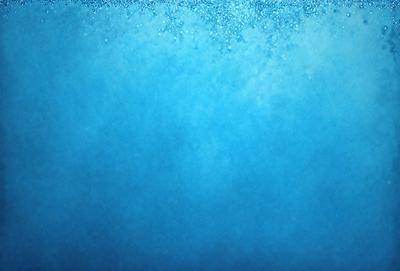 The primary subject of the image is a blue background with a few white bubbles floating in it. The setting appears to be a swimming pool or a body of water with a blue tint. The visual style of the image is a close-up of the blue background, showcasing the bubbles and the water. The colors and mood of the image are predominantly blue and serene, creating a calm and relaxing atmosphere.