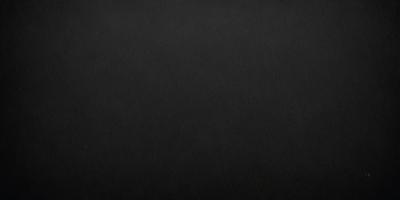 The primary subject of the image is a black background. The setting is a dark room, and the visual style is a black and white photo. The colors and mood of the image are dark and moody, creating a sense of mystery or drama.