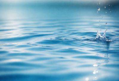 The primary subject of the image is a body of water, which appears to be a large lake or a blue ocean. The water is calm and serene, with no visible waves or disturbances. The setting is a vast, open space, with no visible land or structures in the background. The visual style of the image is a close-up of the water, showcasing its depth and tranquility. The colors in the image are predominantly blue, which adds to the overall mood of the scene.