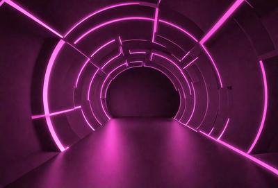 The primary subject of the image is a pink tunnel with a purple light. The setting is a dark room, and the visual style appears to be a digital art or illustration. The dominant colors in the image are pink and purple, creating a warm and inviting atmosphere.