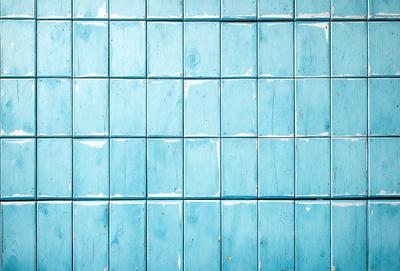 The primary subject of the image is a blue tile wall. The setting is a room with a blue tile wall, and the visual style is a photo. The dominant colors are blue and white, creating a calm and soothing atmosphere.