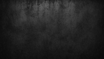 The primary subject of the image is a black and white photo of a wall. The setting is a dark room with a black background. The visual style is a black and white photo, which gives the image a classic and timeless appearance. The colors and mood are predominantly dark and moody, with the black and white tones adding to the overall atmosphere.
