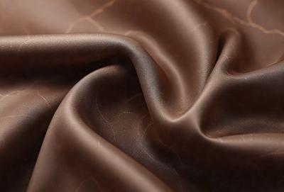 The primary subject of the image is a piece of brown fabric, possibly a piece of leather. The setting is a close-up view of the fabric, showcasing its texture and details. The visual style is a realistic representation of the fabric, with no indication of digital manipulation or artistic elements. The colors and mood of the image are predominantly brown, giving it a warm and natural appearance.