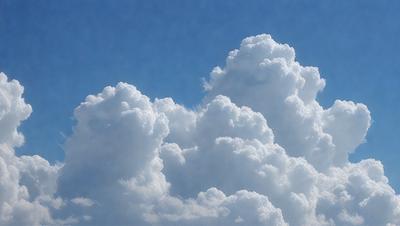 The primary subject of the image is a large, fluffy cloud in the sky. The cloud is the main focus of the image, and it appears to be a natural, outdoor scene. The visual style of the image is a photo, capturing the cloud's texture and details. The cloud is predominantly white, giving it a soft and gentle appearance. The overall atmosphere of the image is serene and peaceful, as the cloud floats gracefully in the blue sky.